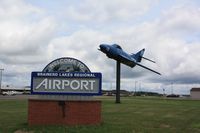  - Entrance sign and plane on pole - by Timothy Aanerud