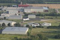  - While departing Airventure on Runway 36 I was taking pictures of the Oshkosh truck inventory.  On a closer look of my photos I spotted Basler Turboprop Conversions facility. There's a B-25 in this photo too. - by Timothy Aanerud