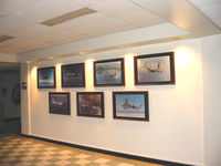  @ Kalaeloa (john Rodgers Field) Airport - Hawaiian Aviation Preservation Society (HAPS) members work after revamping tower lobby with historic pictures of the airports past aircraft - by Ewa Marine