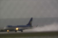  - Frontier Airlines Embraer on 28R during rain storm.  Photo was taken with a 1950's Takumar 200mm screwmount lens with a diffusion filter to create a dreamy effect. - by Daniel Ihde