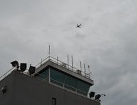  - A Southwest Airlines 737 is seen flying over the Air Traffic Control Tower on a rainy, cloudy day at Burke Lakefront Airport.  - by aeroplanepics0112