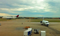  - An AirTran B717 taxies to the gate with a Delta B747 in the background - by Murat Tanyel