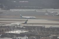  - Not top quality - it is cloudy and hazy, we are moving and the windows were scratched on my plane N744P (US A319 Piedmont colors).  ATI DC-8 lands on parallel runway, UPS 767 in foreground and large GA ramp in background - by Florida Metal