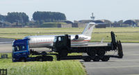  - A truck carrying a Flat bed truck passes a Vistajet CRJ200 - by Mike stanners