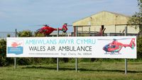  - Sign by the entrance to Swansea Airport showing the charity (Wales Air Ambulance) funding the three air ambulance helicopters operating in Wales. The Swansea based air ambulance helicopter (Helimed 57) is responding to an emergency - by Roger Winser