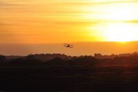 - Biplane arriving at sunset. - by Roger Winser