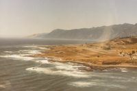  - Passing by Shelter Cove on a windy day in 1982. Big Flat (seen in 2 of my N8059X pictures) is in the top left of pic where the dark part of the mountain range ends.It is now Kings Range National Conservation Area known as The Lost Coast. - by S B J