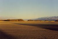  - View from the tiedown area toward the  runway and to the NW. Visibility is often unlimited.Frist time flying into D V,pilots will be amused to see the altimeter go below zero by some 200 feet and a 600 ft pattern (altimeter) is in order. - by S B J