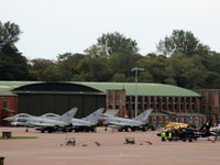  - Busy apron at RAF Leuchars with three Typhoons from the based 6 Sqn and a 100 Sqn Hawk sharing the space. In the background is a good view of one of the original WWII hangars. - by Clive Pattle