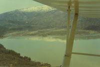 - View is from the south to the north-northwest and Hull Mt with its winter covering of snow. This picture shows why for some aircraft, it is a one way strip. Good size hill to climb over. - by S B J