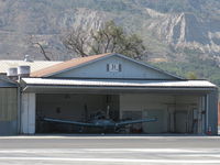 - Santa Paula Airport Do-It-Yourself Aircraft Paint Facility. Rare to see doors open, some masking of a Piper PA-28 is being done, and it is already hot mid-morning. - by Doug Robertson
