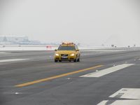  - Volvo friction car at work. Vehicle has a 5th wheel between the axels and a computer to determine runway friction values during snow removal. - by Gerald Howard
