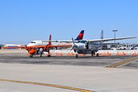  - Islander & Caravan parked on the back country ramp to transport passengers into the mountains. - by Gerald Howard