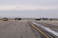  - Disabled A-10 being towed off runway followed by emergency equipment. - by Gerald Howard
