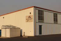  - New signage at the far-west end of the airport; technically, these comparatively newer rows of deluxe hangars are off-airport and pay an annual taxi fee.  - by Doug Robertson