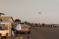  - CROMAN helicopter on departure to the Thomas Fire from SZP FireBase. Note PHOS-CHEK sling load and smoky sky. - by Doug Robertson