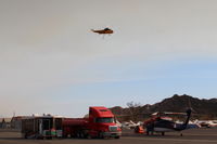  - CROMAN helicopter with Phos-Chek sling load dumped, returning to SZP Firebase. Note smoky sky. - by Doug Robertson