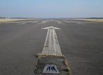  - Arrow pointing to the displaced threshold of Runway 10 at the closed Vaerloese Air Base in Denmark. In the foreground a white approach light. - by Jan Lundsteen-Jensen