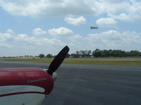 La Belle Municipal Airport (X14) - PA-24 180 Piper Comanche (N7569P) in foreground as unknown aircraft takes off on new runway at LaBelle, Fl. - by Don Browne