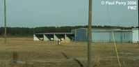 Palmar Sur Airport - Another shot of the hangars, with a boat in the nearest one - by Paul Perry