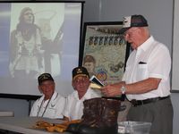 Grimes Field Airport (i74) - Veterans Seminar.  Beyond speaker Art Kemp are a poster dedicated to Art and a photo of him right after he shot down 2 German fighters. - by Bob Simmermon