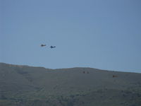 Santa Paula Airport (SZP) - N133JH, N104A, N3G and N131MR forming up on departure from the National Bucker Fly-In. South Mountain in background. - by Doug Robertson