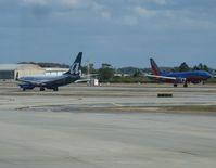 Orlando International Airport (MCO) - Southwest 737 landing as an AirTran 737 taxis for departure. - by Kreg Anderson