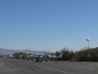 Santa Paula Airport (SZP) - Taut windsock Rwy 04 during strong Santana wind from E-SE. Riverbank tiedown aircraft behind. Thirty-five knot winds with gusts forecast. - by Doug Robertson