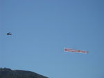 Santa Paula Airport (SZP) - N65124 Boeing Stearman towing FOLLOW THE BACON-Carl's Jr. advertising banner past South Mountain viewable by all of Santa Paula, CA. - by Doug Robertson