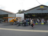 Santa Paula Airport (SZP) - The Pat Quinn Bucker Museum hangar with his Jungmeister 'Angel' flanking the hangar. Big barbecue luncheon with over 150 guests for his 50 year FAA Wright Brothers Master Pilot Award. Has owned 55 airplanes in 50 years!!! - by Doug Robertson