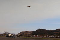 Santa Paula Airport (SZP) - CROMAN helicopter with PHOS-CHEK sling load departing SZP FireBase, note smoky sky - by Doug Robertson